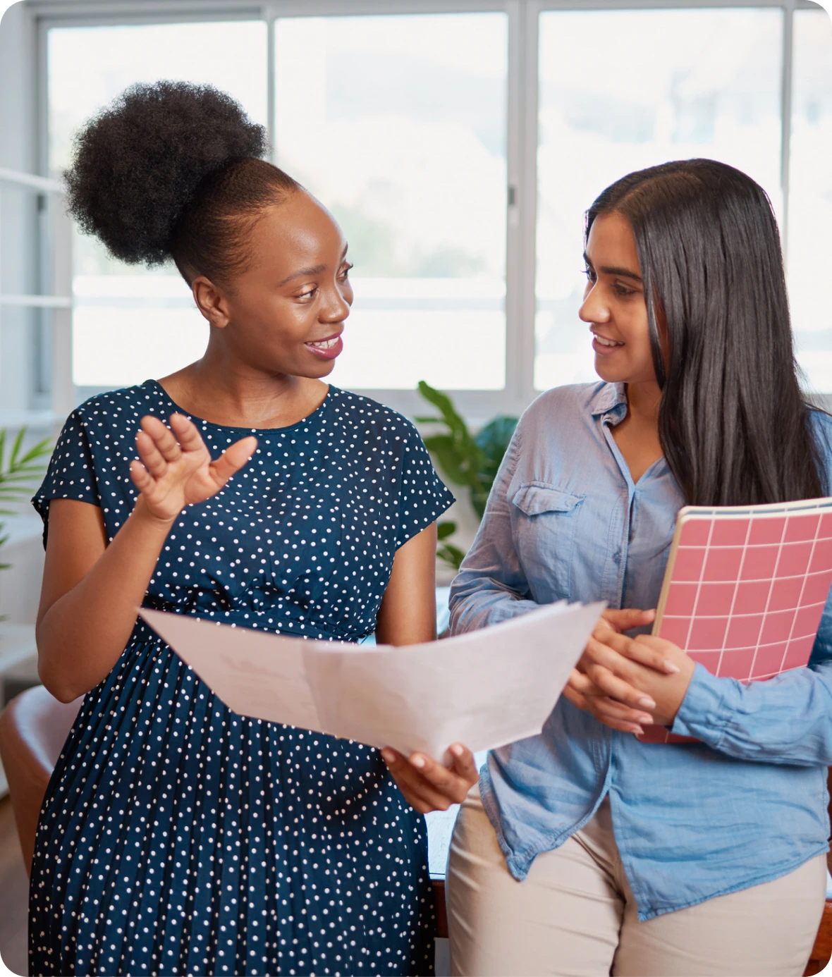 Two women discussing work documents
