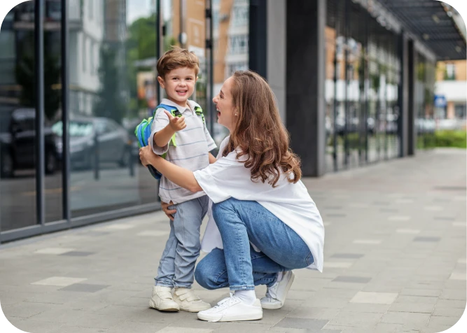Woman kneeling, embracing smiling child